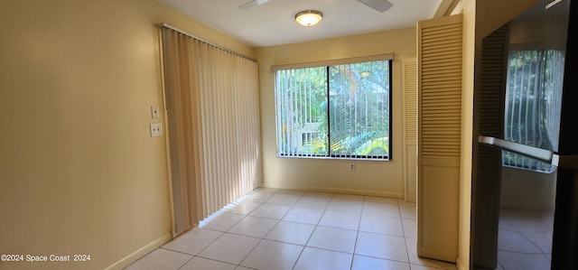 tiled empty room featuring ceiling fan