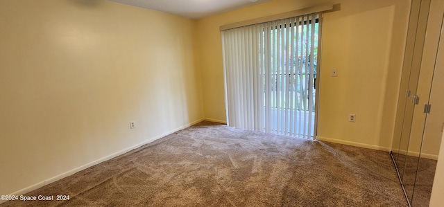 carpeted empty room with baseboards