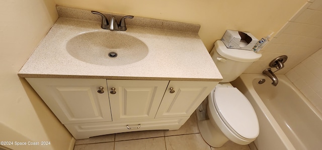 bathroom featuring tile patterned flooring, vanity, toilet, and a bathing tub