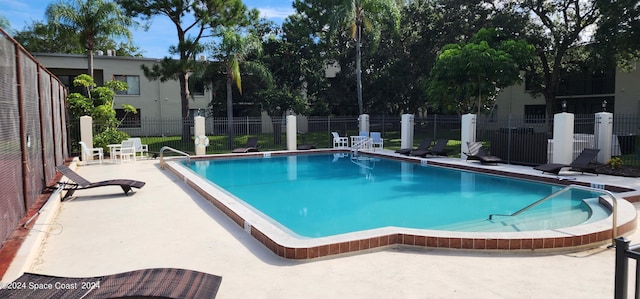 pool featuring fence and a patio area