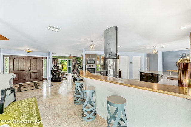 kitchen featuring ceiling fan, kitchen peninsula, and stainless steel fridge with ice dispenser