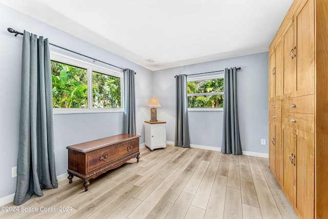 bedroom with light wood-type flooring and multiple windows