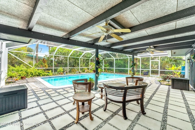 view of swimming pool featuring ceiling fan, a lanai, and a patio area