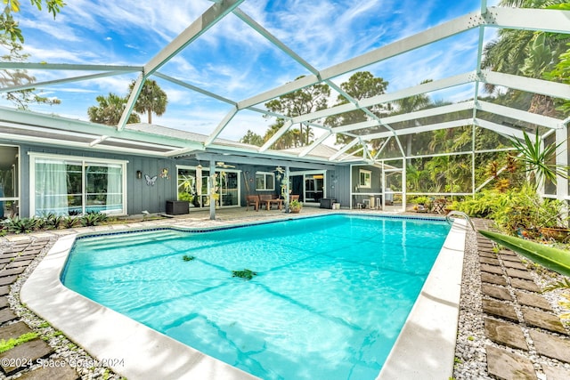 view of swimming pool with glass enclosure, a patio, and central AC unit