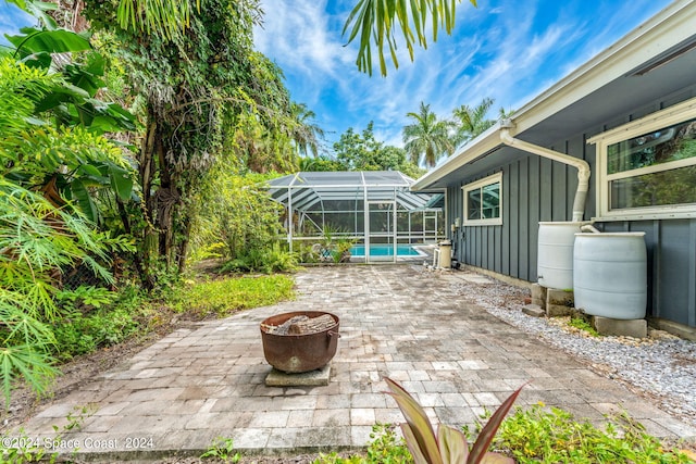 view of patio featuring a lanai and an outdoor fire pit