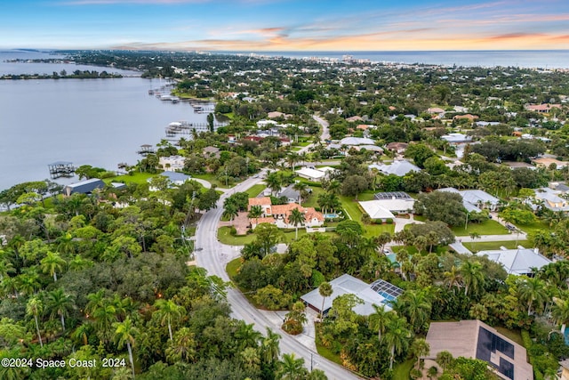 aerial view at dusk featuring a water view