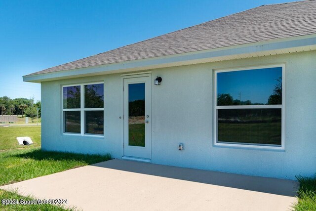 view of side of home featuring a patio area and a yard