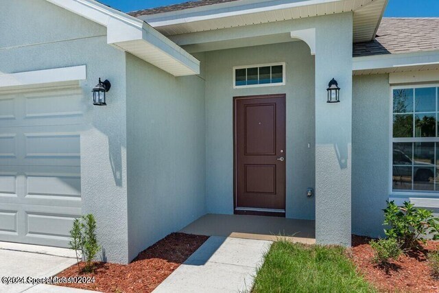 doorway to property with a garage