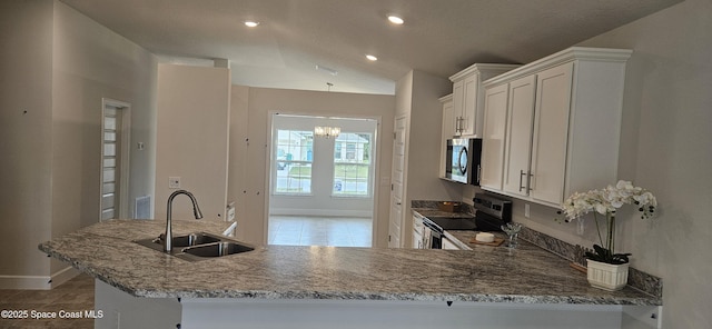 kitchen featuring white cabinetry, sink, stainless steel appliances, and kitchen peninsula