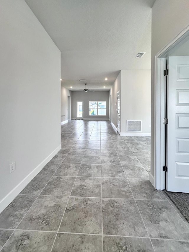 interior space with tile patterned floors, a textured ceiling, and ceiling fan