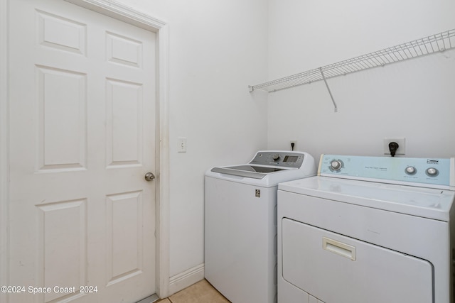 washroom featuring washing machine and dryer and light tile patterned flooring