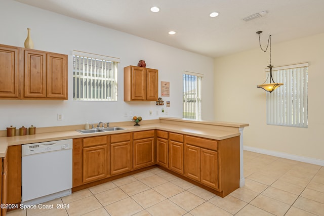 kitchen with light tile patterned flooring, sink, white dishwasher, kitchen peninsula, and pendant lighting