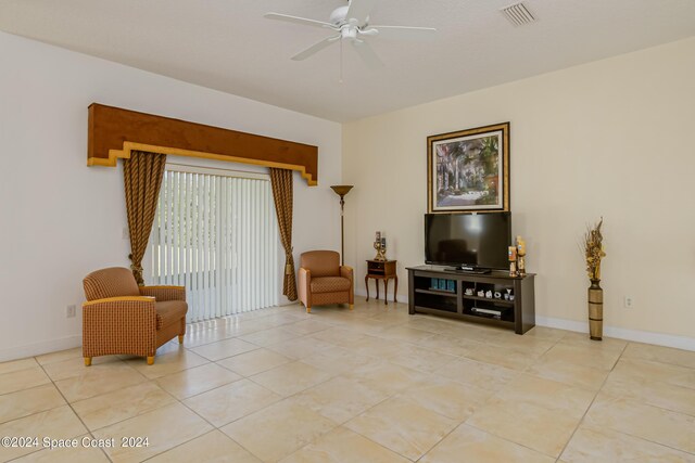 living area with ceiling fan and light tile patterned flooring