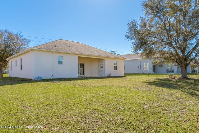 rear view of house featuring a yard