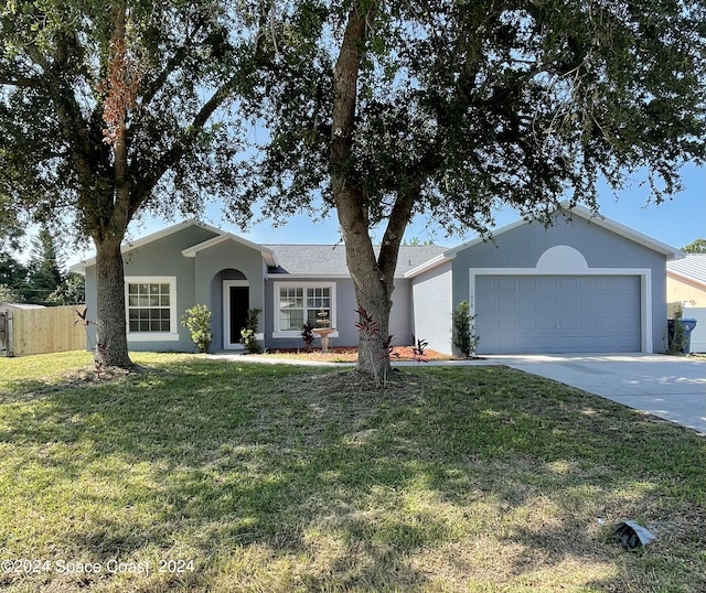 ranch-style home with a garage and a front lawn