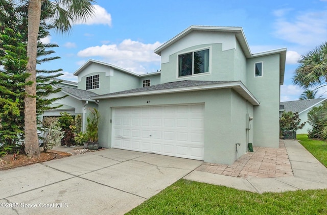 view of front facade featuring driveway, an attached garage, and stucco siding