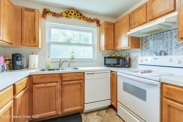 kitchen with light countertops, brown cabinetry, a sink, white appliances, and under cabinet range hood