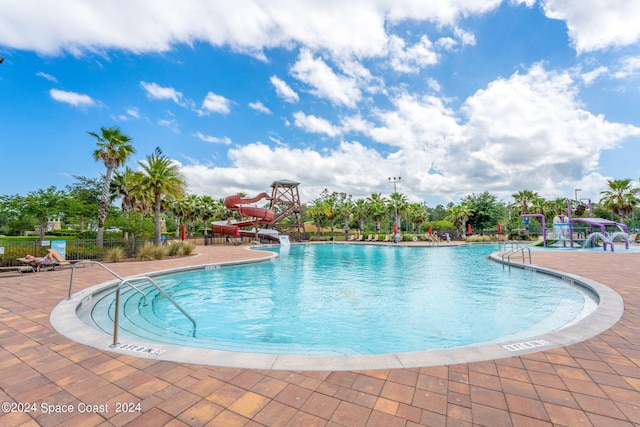 view of pool featuring a water slide and a patio area