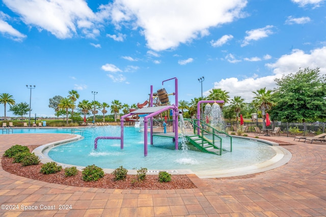 view of pool with pool water feature and a playground