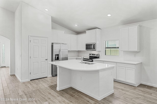 kitchen featuring an island with sink, stainless steel appliances, white cabinets, and vaulted ceiling