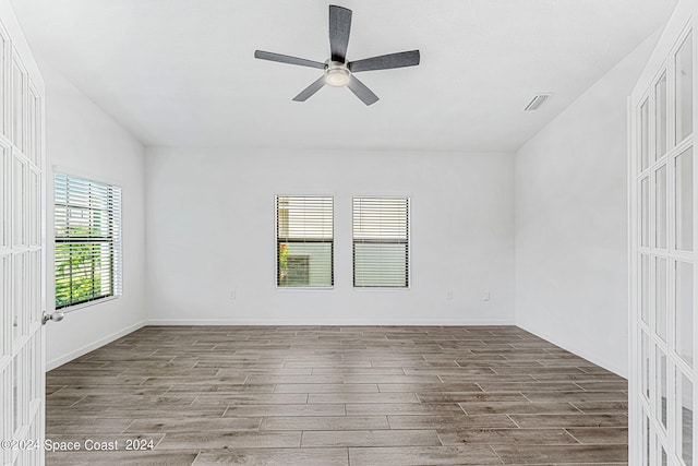 empty room with ceiling fan and hardwood / wood-style floors