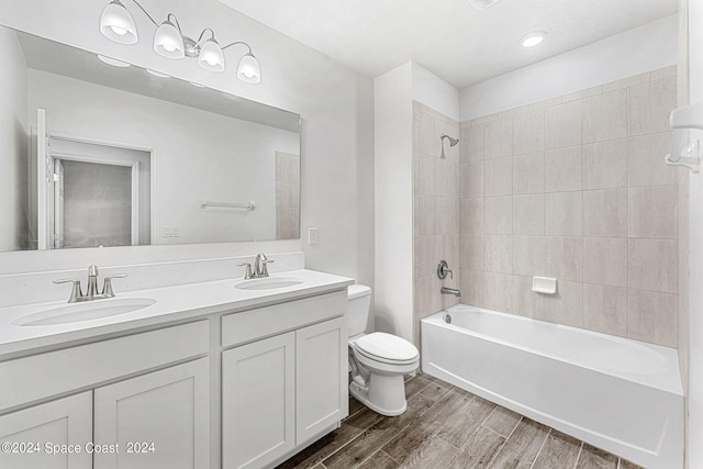 full bathroom with tiled shower / bath combo, vanity, toilet, and wood-type flooring