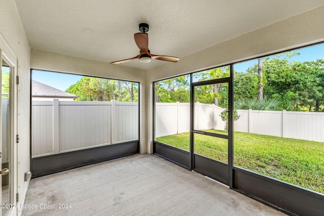 unfurnished sunroom with ceiling fan