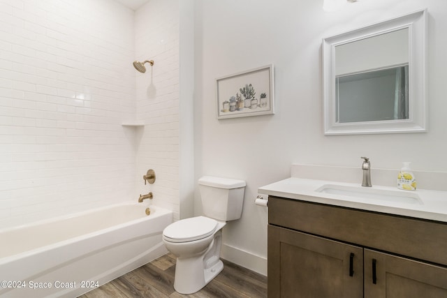 full bathroom featuring wood-type flooring, toilet, tiled shower / bath combo, and vanity