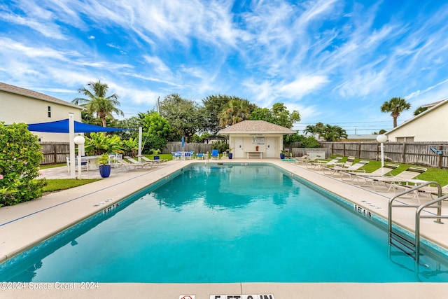 view of pool with a patio and an outdoor structure