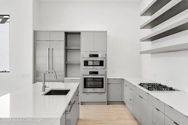 kitchen featuring sink, gray cabinets, appliances with stainless steel finishes, and light hardwood / wood-style floors