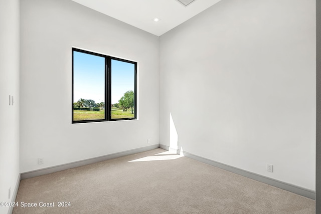 unfurnished room featuring lofted ceiling and carpet flooring