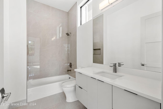 full bathroom featuring tile patterned flooring, toilet, tiled shower / bath combo, and vanity