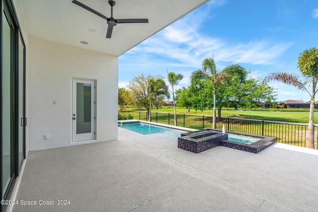 view of swimming pool with a water view, a lawn, a patio area, and an in ground hot tub