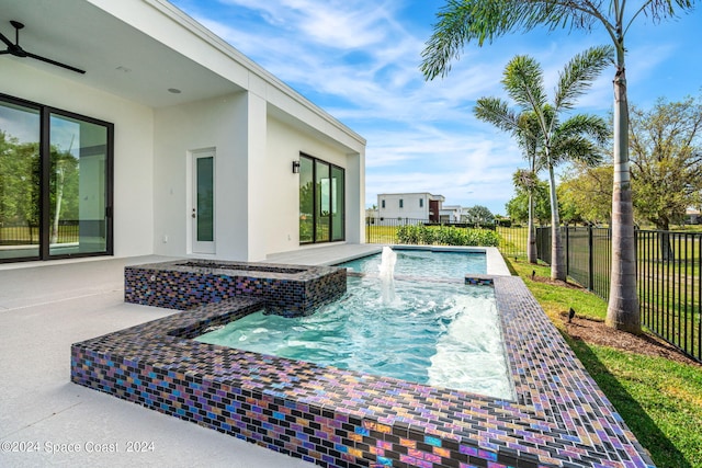 view of swimming pool with pool water feature and a patio area