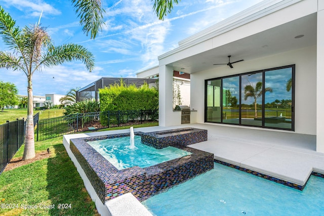 view of swimming pool featuring a patio, pool water feature, a yard, ceiling fan, and area for grilling