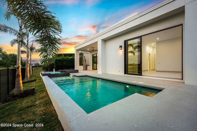 pool at dusk with a patio