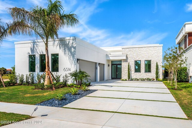 modern home with a front yard and a garage