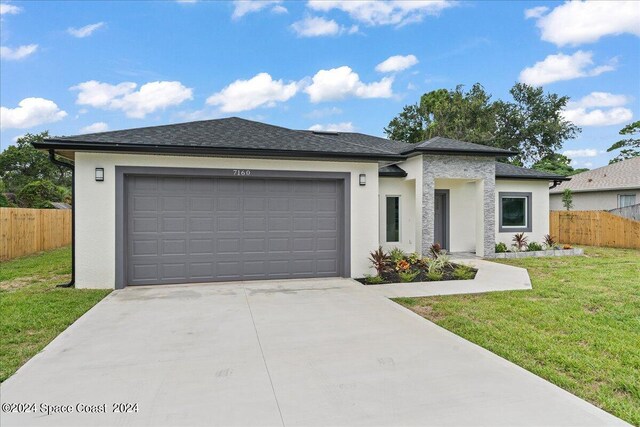 view of front of property with a garage and a front yard