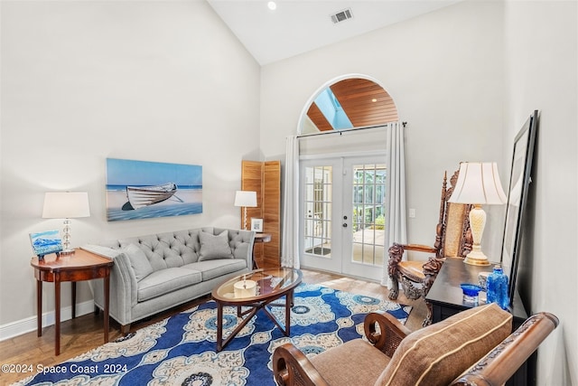 living room featuring french doors, high vaulted ceiling, and hardwood / wood-style flooring