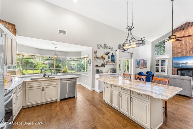 kitchen featuring sink, a kitchen bar, a kitchen island with sink, appliances with stainless steel finishes, and hardwood / wood-style flooring