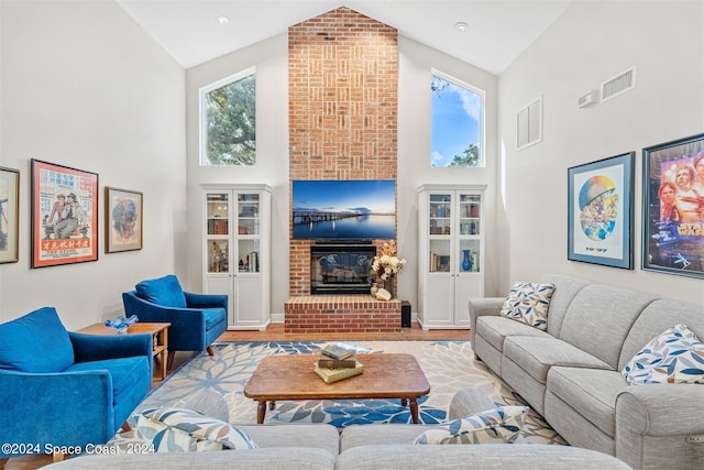 living room with a healthy amount of sunlight, a fireplace, and high vaulted ceiling