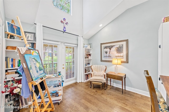 living area featuring high vaulted ceiling and light wood-type flooring