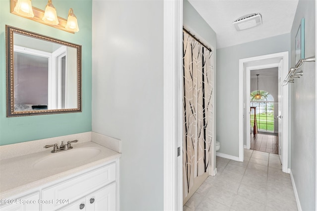 bathroom with tile patterned floors, a shower with curtain, vanity, and toilet