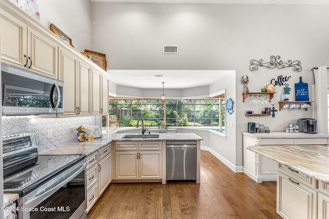 kitchen with cream cabinetry, light wood-type flooring, sink, and appliances with stainless steel finishes