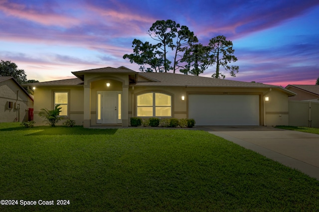 prairie-style home featuring a garage and a lawn