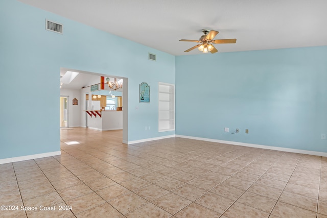 unfurnished room with ceiling fan with notable chandelier and light tile patterned flooring