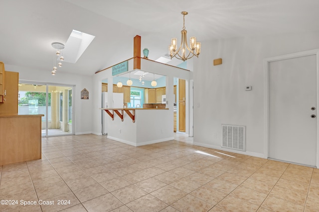 unfurnished living room with light tile patterned flooring, a notable chandelier, and lofted ceiling with skylight