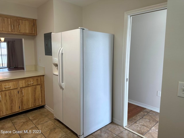 kitchen with white refrigerator with ice dispenser and light tile patterned floors