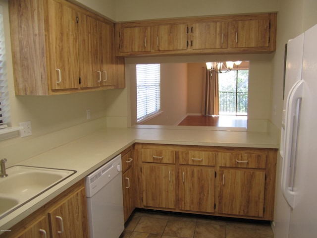 kitchen featuring tile patterned flooring, white appliances, a chandelier, and sink