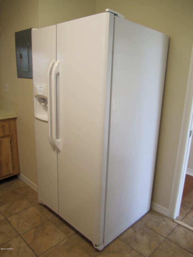 details featuring white refrigerator with ice dispenser, electric panel, and tile patterned floors